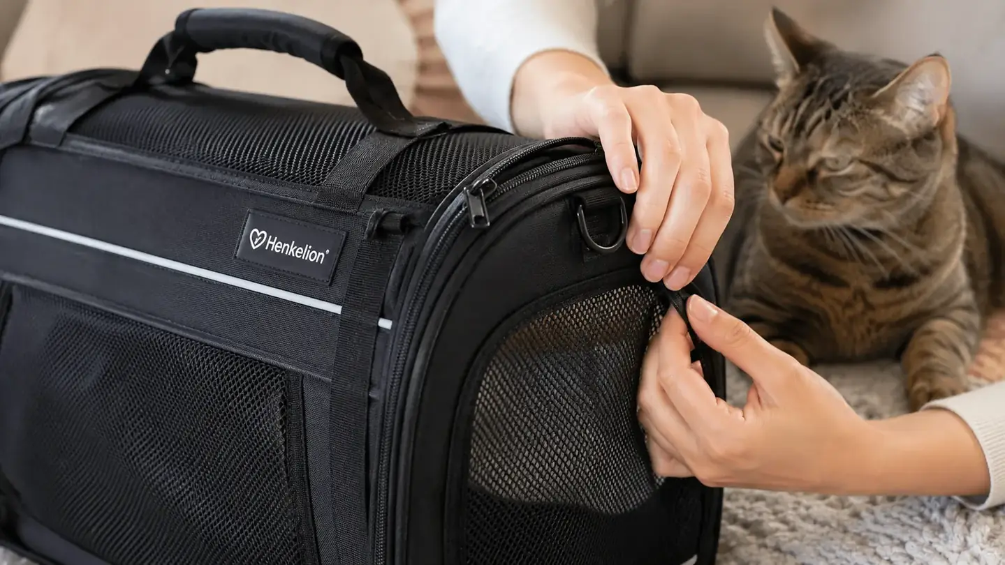 A person running their fingers along the zipper and seam of a soft-sided carrier to inspect the stitching